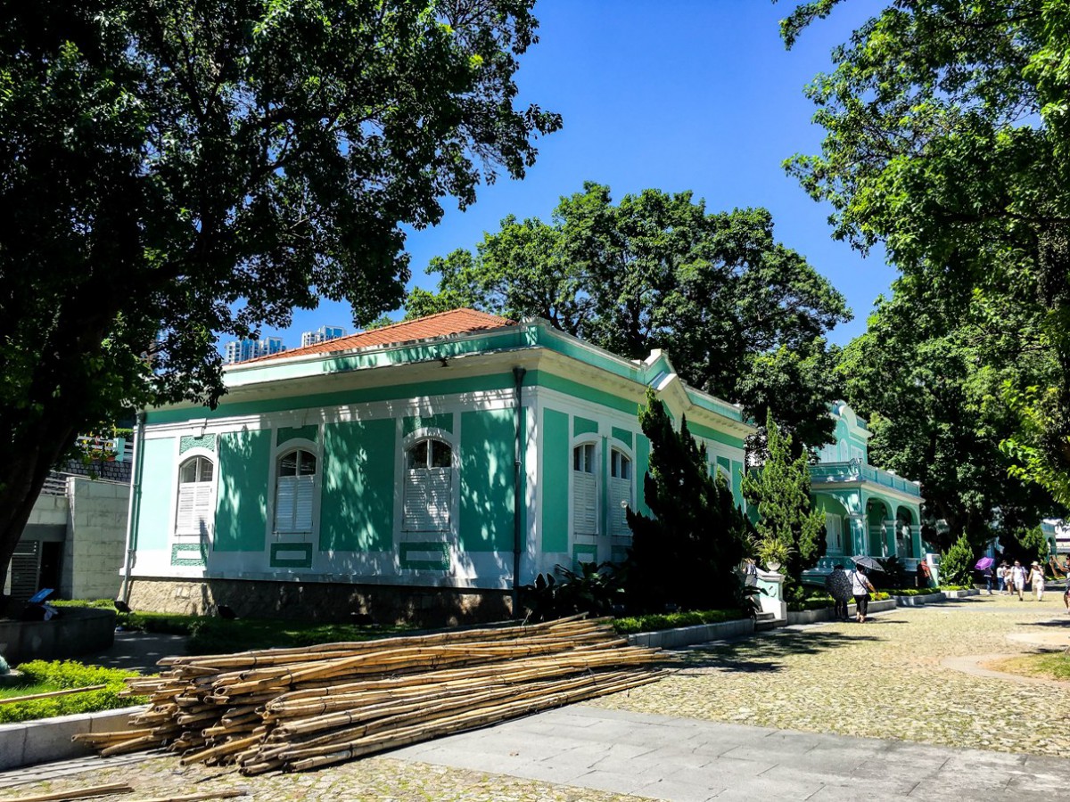 A stack of bamboo beside a colonial house